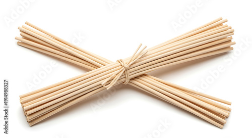 Two bundles of natural light brown wooden diffuser reeds tied with twine and crossed on a white background.