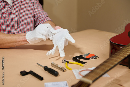 Fotografie Guitar String Maintenance and Repair With Tools and Gloves on Worktable
