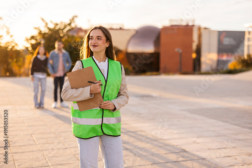 Female student in safety vest conducting field research