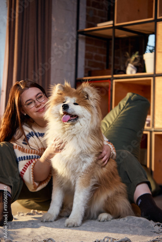 Fotografie Close up of smiling dog with owner relaxing on bean bag