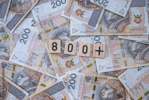 800 Polish zloty banknotes arranged as a financial background with wooden tiles showing eight hundred plus