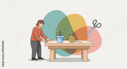 Woman working at a wooden table with craft supplies and a plant
