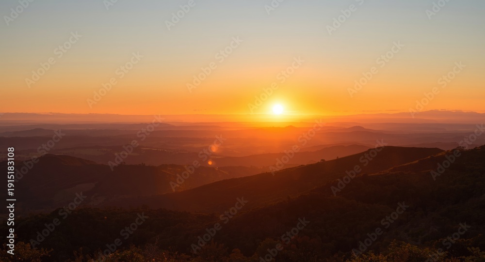 Obraz premium Sunset glowing over rolling hills with layered horizons and copy space for captions