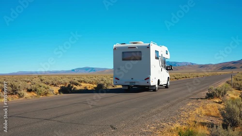 White RV Traveling Down Desert Road.