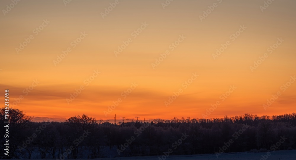 Naklejka premium Winter twilight sky glowing with rich golden shades and calm