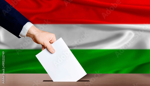 Hungary parliamentary vote 2026. Hand placing a ballot in ballot box with the Hungarian flag in the background.