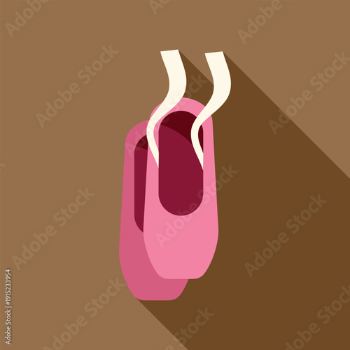 Pink ballet pointe shoes hanging with long shadow on brown background