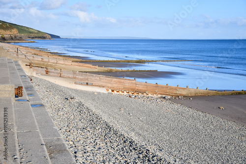 Long shore drift on beach in Pembroke, the wooden groynes preventing too much sand moving along the beach towards the cliff.