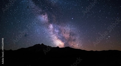Starry night sky featuring bright constellations and distant mountain silhouettes with generous copy space for text overlay