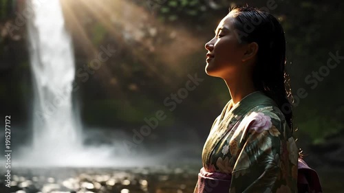 Serene young woman standing by a majestic waterfall, lost in thought with lush greenery and sunbeams dancing across her face and the misty atmosphere.