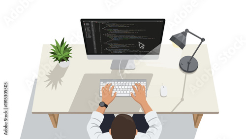 Overhead view of a person coding at a computer workstation with a plant and desk lamp.