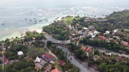 Aerial view of coral reef and turquoise ocean during early morning low tide at Weligama Beach, Sri Lanka. Crystal clear azure water, exposed reef formations, and peaceful tropical coastline. Perfect f