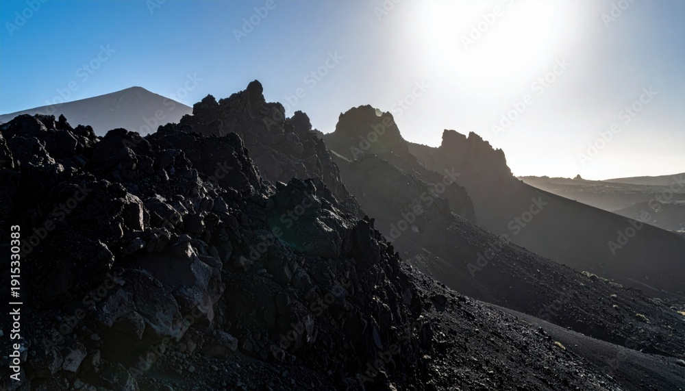 Obraz premium Dramatic Craggy Volcanic Mountain Slopes Bathed in Sunlight, Showcasing Rugged Terrain