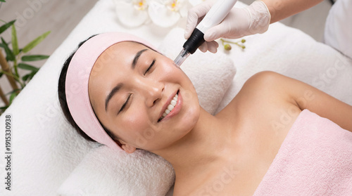 美容クリニックでダーマペンの施術を受ける笑顔の若い日本人女性、美肌とアンチエイジングのためのスキンケア