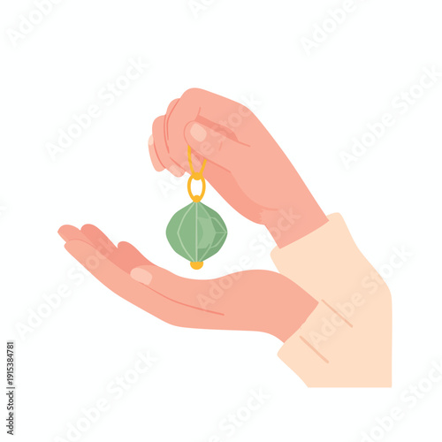 A hand holding a green leaf-shaped pendant on a chain from a top view
