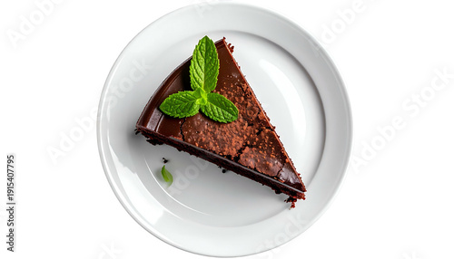 Overhead view of a dark chocolate cake slice with mint garnish on a white plate