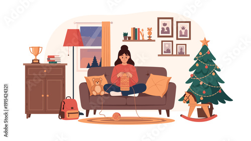 Young woman knitting a scarf while sitting comfortably on a sofa in a cozy living room decorated for the festive Christmas season.