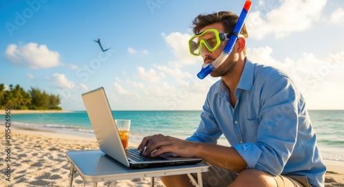 Man working on laptop at beach with snorkeling gear.