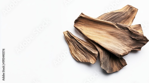 Aromatic oud wood chips displayed on a clean white surface for incense and fragrance