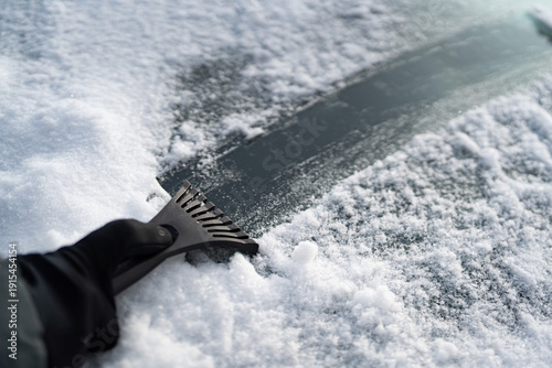 Scraping Ice and Snow from Car Windshield on a Cold Winter Morning