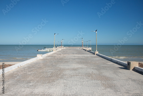 Bild auf Leinwand Sisal, Mexico; November 1st, 2025: People strolling along the boardwalk on the beach during a summer day