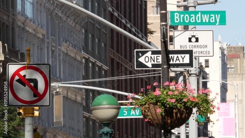 New York City Broadway street sign in Manhattan Midtown, United States. Urban road sign, traffic sign. Building architecture in Flatiron district. Crossroad with 5 fifth avenue. Subway metro lamp.