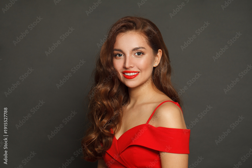 Naklejka premium Successful brunette woman with trendy make-up and brown curly hair wavy hairstyle and red lips makeup on black background