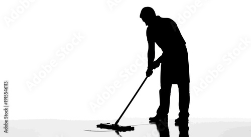 Silhouette of a person cleaning the floor with a mop.