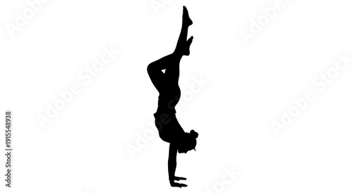 Silhouette of a woman performing a handstand yoga pose.