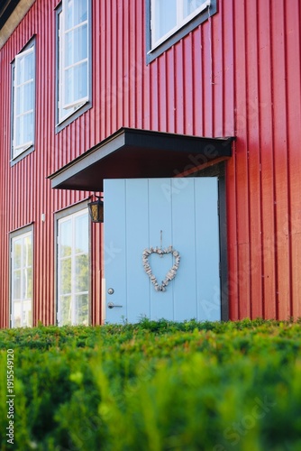 Cozy wooden house entrance with blue door and heart decoration
