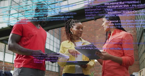 Obraz Discussing trio in red yellow coral shirts reviewing tablets, documents in loft with code overlay