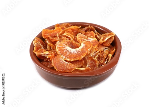 Fotografía Dried segments of clementines in a ceramic bowl on white background
