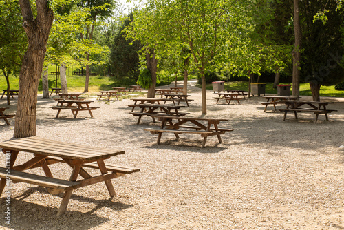Wooden picnic tables in public park outdoor recreation area