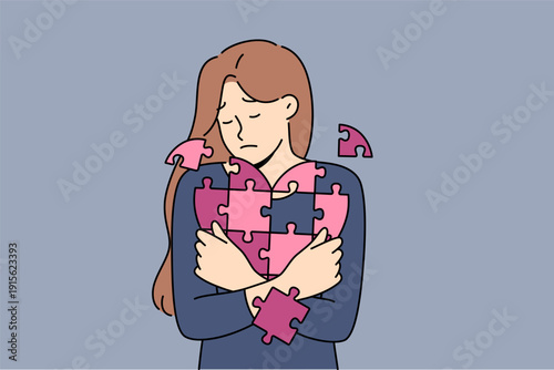 Woman hugging broken heart puzzle with sad expression