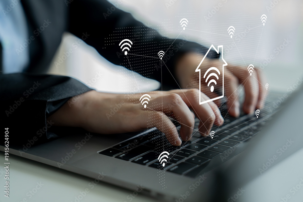 Naklejka premium A professional man types on a laptop, highlighting the integration of smart home technology symbols, showcasing the blend of modern work and advanced connectivity. Gantry