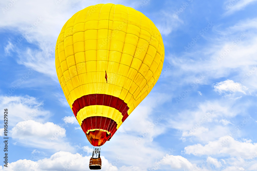 Obraz premium Colorful hot air balloon flying over blue sky with white clouds