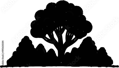Silhouette of a large tree with smaller trees or bushes in front and sides