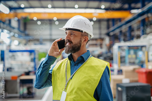 A portrait of project manager or engineer factory, making phone call.