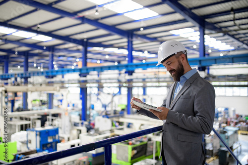 Canvastavla Senior industrial manager reviewing production data on tablet in modern factory