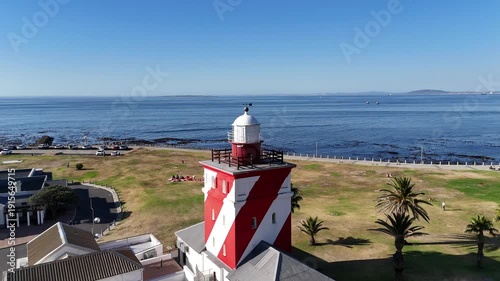 Drone does 360 around red and white lighthouse on sunny day in Green Point, Cape Town, South Africa