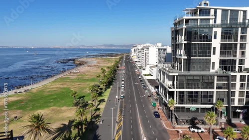 Drone flies east along Beach Road on sunny day in Green Point, Cape Town, South Africa