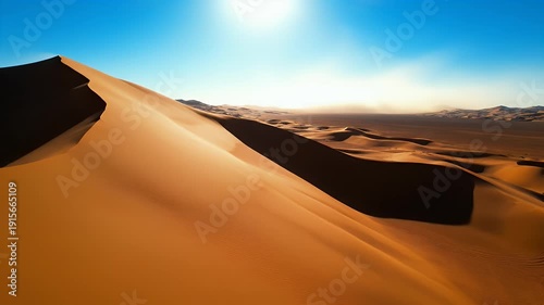 Expansive desert dunes under a bright sunlit blue sky with windblown sand