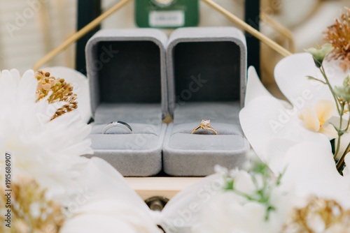 Foto Pair of Wedding Rings in Velvet Boxes with White Flowers