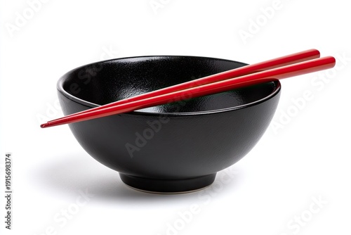 A glossy black bowl with bright red chopsticks resting on its rim