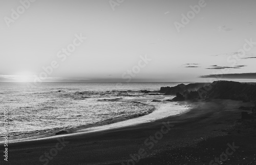 Black and white ocean waves and shoreline at sunset in Iceland