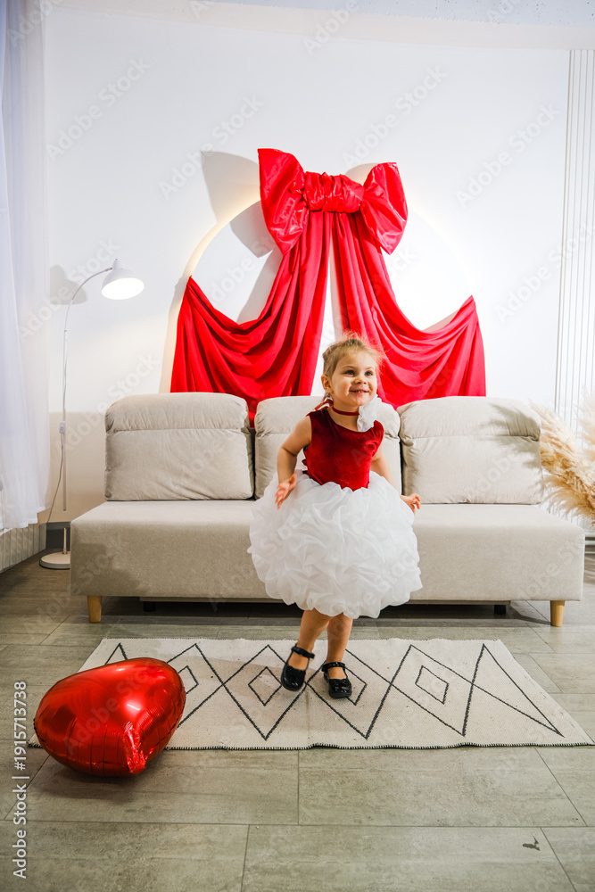 Obraz premium Moscow, Russia, 08.02.2026 Caucasian kid girl in cute dress jumping with heart balloon. Happy childhood and celebration concept for Mother Day and Valentine Day.