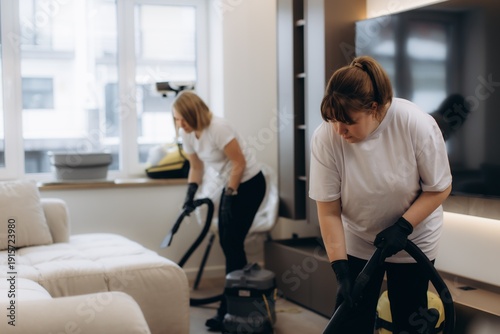 Konstfotografi Professional cleaning team vacuuming upholstered furniture in living room
