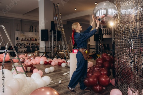 Canvastavla Event decorator installing silver balloon at celebration