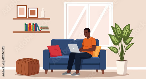 A man sitting on a blue couch using a laptop in a cozy living room with a potted plant nearby indoors.