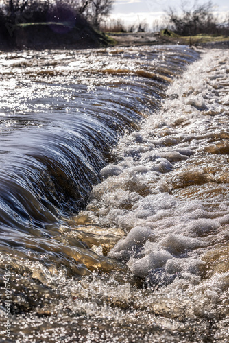 A caution sign of rushing waters in the Irish bridge, Irish crossing or ford, a dangerous passage during the heavy rain season at the Evros Delta National Park in Greece, flowing water